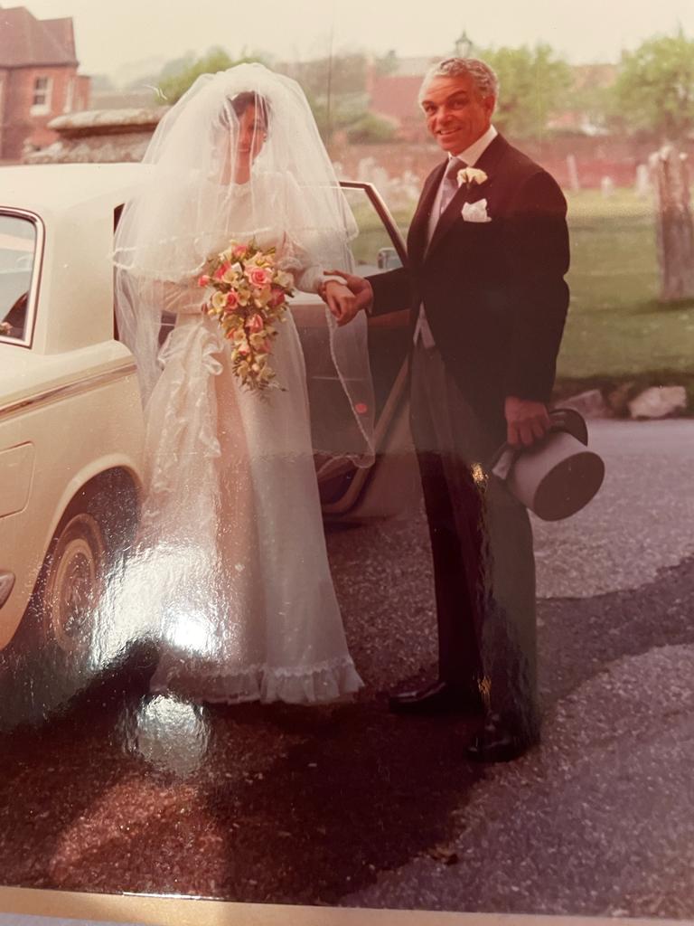 Charlie Hutchison poses with his daughter on her wedding day, Christchurch priory, 1974.