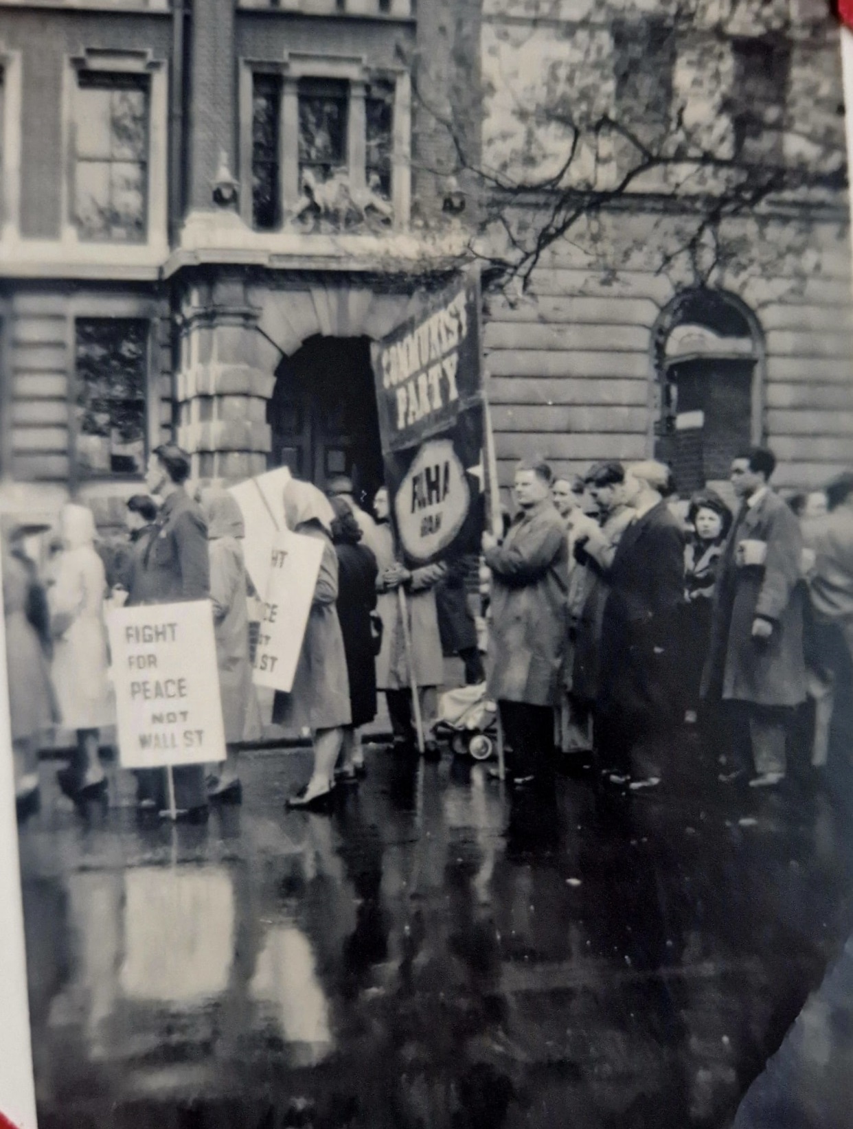 Charlie Hutchison (far right) with newspaper underarm, taking part in a political demonstration. Photograph likely taken in London. between 1930s-1950s.