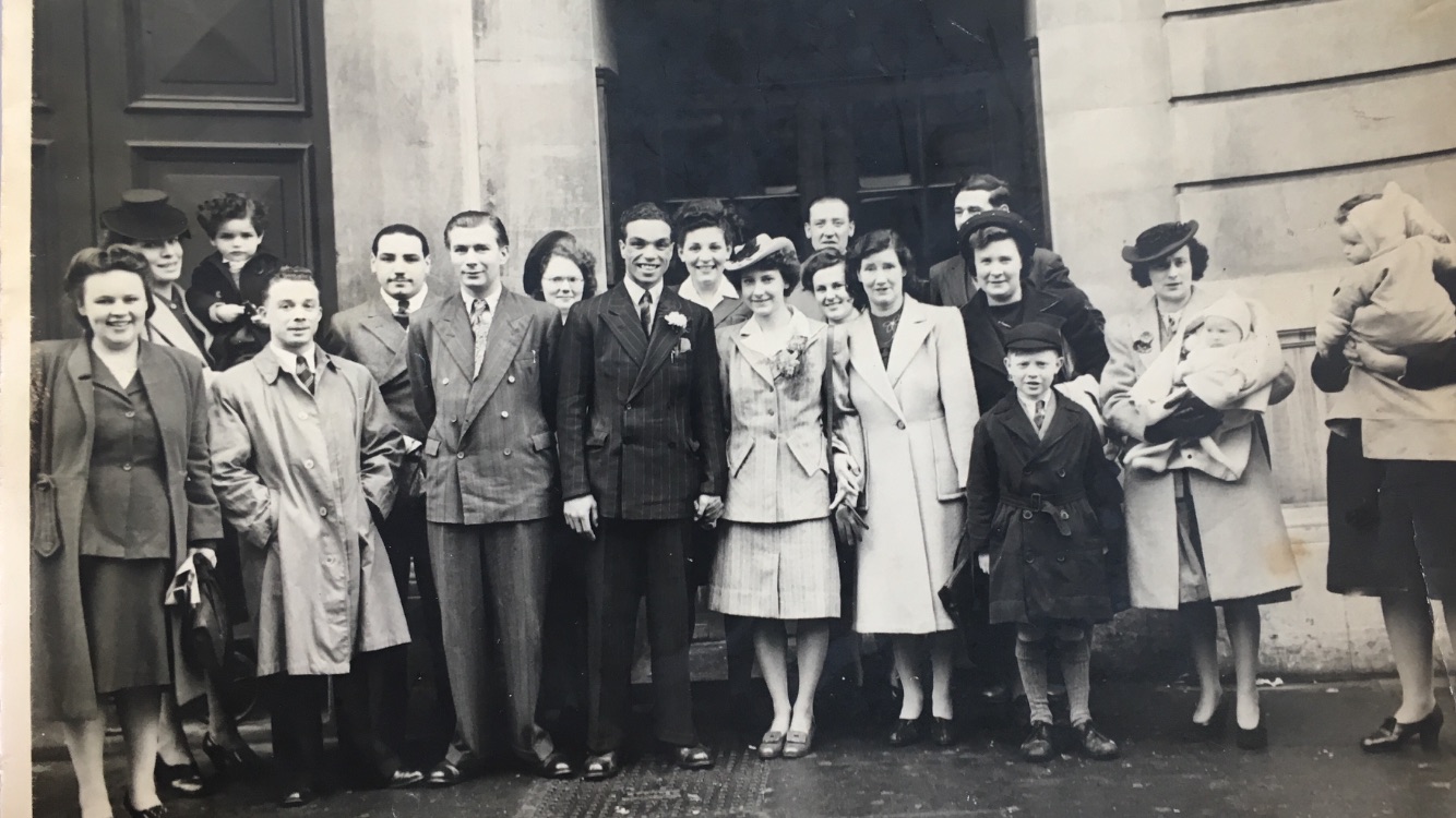 Charlie Hutchison (suit, centre) and his wife Patricia Holloway (1926-2006) pose with guests at their weding. Photograph taken in London, 29 March, 1947.
